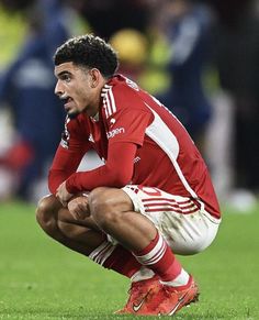 a soccer player crouches down on the field