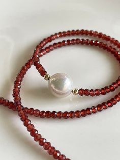 "A lovely 10mm white Edison pearl, slightly-wrinkled and with great luster, is framed by dainty faceted 2mm diamond-cut garnets to make a beaded choker necklace. Sparkles in the sun like crazy! Measures 16\", with a 2\" extender chain to bring it to a total length of 18\". Looks beautiful alone or layered with any other of my garnet necklaces in my shop! Your jewelry will come gift-boxed, and gift-wrapping is available upon request. Thank you for checking out my shop!" Garnet Beads Jewelry, Garnet Bead Necklace, Red Gemstone Necklace, Red Garnet Necklace, Dainty Gemstone Necklace, Red Beaded Necklaces, Beaded Necklace Patterns, Jewerly Beads, Beading Jewelery