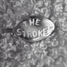 a spoon with the words the strokes written on it sitting in a bowl full of cereal