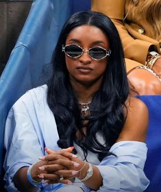 a woman wearing sunglasses sitting in the stands