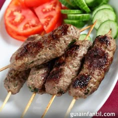 meat skewers with vegetables and cucumbers on a plate