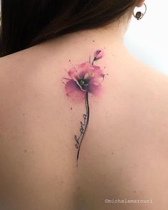 the back of a woman's neck with a pink flower tattoo on her left shoulder