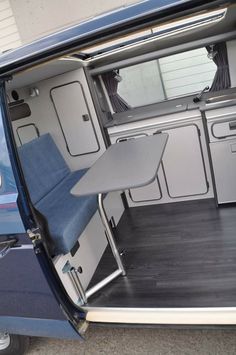 the inside of a van with its door open and table in the back ground area