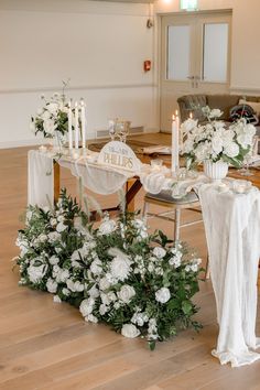 the table is set with white flowers and candles