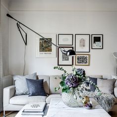 a living room filled with lots of furniture and pictures on the wall above it's coffee table