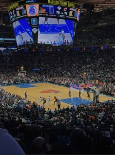 a basketball game is being played in an arena with people watching from the sidelines