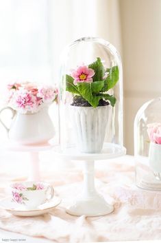 there is a glass clochet with flowers in it on top of a table