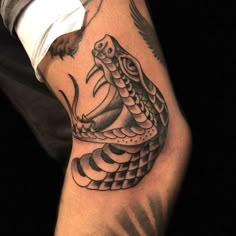 a man's arm with a snake tattoo on it and an eagle flying above