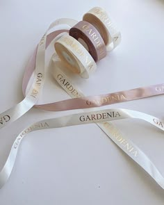 three rolls of satin ribbons with the names of various countries on them, sitting next to each other