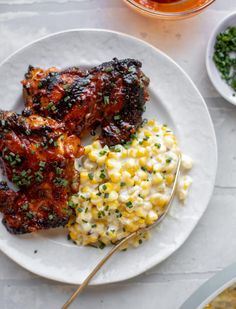 grilled chicken, corn and mashed potatoes on a white plate with a spoon