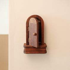 a wooden clock mounted to the side of a wall