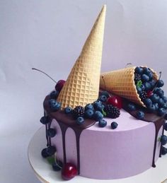 an ice cream cake topped with blueberries and raspberries