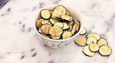 a white bowl filled with sliced bananas on top of a marble counter next to a knife