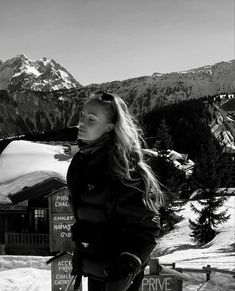 a woman standing on top of a snow covered slope