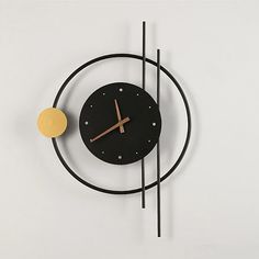 a clock that is on the side of a wall with black and gold accents,