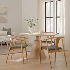 a dining table with two chairs and a potted plant in the middle of it