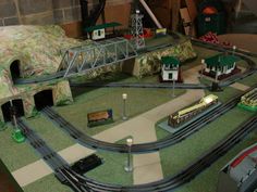 a model train set is shown in the middle of a room with green carpeted flooring