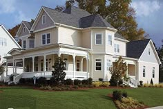 a large white house sitting on top of a lush green field