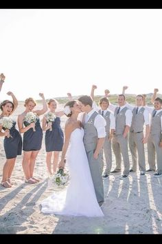 the bride and grooms are posing together on the beach with their bridal party