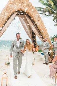 a bride and groom walk down the aisle at their wedding ceremony on the beach in mexico