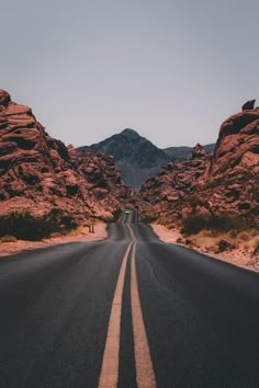 an empty road with mountains in the background