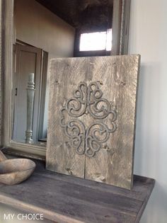 a wooden box sitting on top of a table next to a mirror