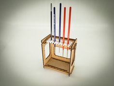 a wooden holder with six different colored sticks sticking out of it's back end