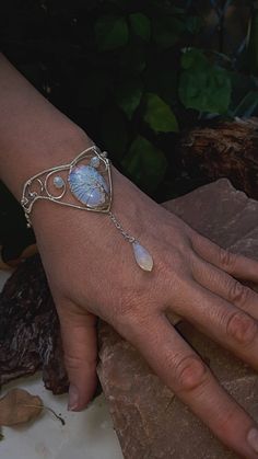 "Moonstone (Opalite) tree of life cuff Bracelet, Silver wire wrapped Tree of life bracelet Fits all sizes 5.5\"-7.5\" Can order in your size or request a size that suites your desire.  This beautiful Tree of Life bracelet is hand-crafted jewelry with Opalite  and Silver plated wire; Opalite is a milky man-made stone of translucent glass and crushed opals. It can transform from a rainbow sheer to a bright blue to flashy yellow depending on the light. The bracelet in the photos was shot in natural Moonstone Moon Magic Jewelry, Elf Jewelry Bracelet, Creative Crystal Jewelry, Handmade Jewelry Bracelets Wire, Wire Mandala Bracelet, Tree Of Life Stone Wrapping, Viking Wedding Jewelry Women, Wire Tree Jewelry, Wire Wrapped Jewelry Stones