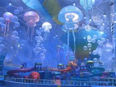 an indoor play area with lots of jellyfish and water balloons hanging from the ceiling