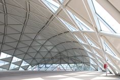 the inside of an airport terminal with white walls and glass windows on each side of it