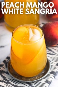 peach mango white sangria is served in a glass with ice and garnish