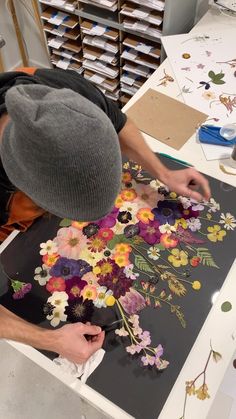 a man working on an art project with flowers