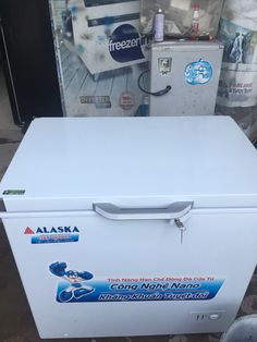 a white freezer sitting next to a pile of cans