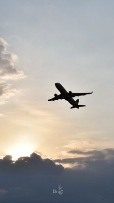 an airplane is flying in the sky at sunset