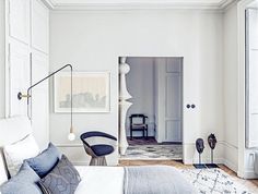 a bedroom with white walls and wooden floors