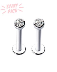 pair of stainless steel ear studs with crystal stones on each end, set against a white background