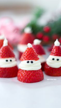 some strawberries with santa hats on them are sitting next to each other in the shape of santa claus