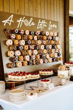 a table topped with lots of doughnuts and pastries on top of plates