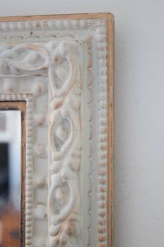 a white framed mirror hanging on the wall