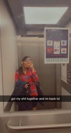 a woman taking a selfie in an elevator