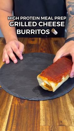 a person holding a piece of food on top of a black plate with the words high protein meal prepped grilled cheese burritos