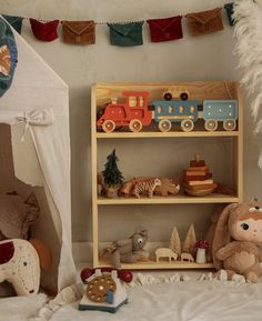 a wooden shelf with toys on it in a child's room next to a tent