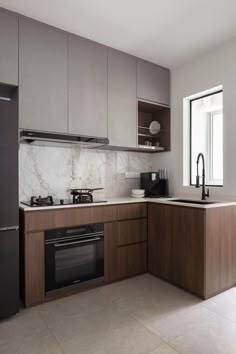 a modern kitchen with marble counter tops and wooden cabinetry, along with stainless steel appliances