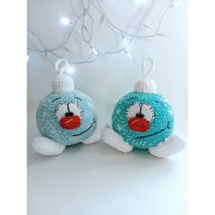 two blue and white ornaments hanging from a christmas tree