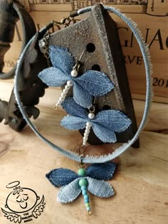 a necklace with blue flowers and beads hanging from it's side on a wooden table