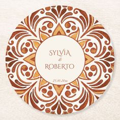 a brown and white wedding coaster with an ornate design on the front, which reads syva & roberto