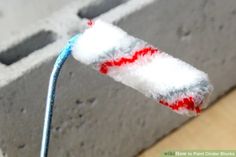 a red, white and blue toothbrush sticking out of the side of a wall