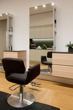 a salon chair sitting on top of a hard wood floor next to a mirror and counter