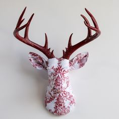 a red and white deer head mounted on the wall