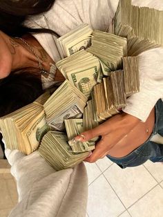 a woman holding stacks of money in her hands